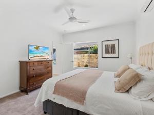 een slaapkamer met een bed, een dressoir en een raam bij Parkside Noosa River in Noosaville