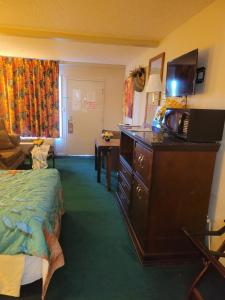 a hotel room with a bed and a dresser with a microwave at Express Inn and Suites in Gastonia