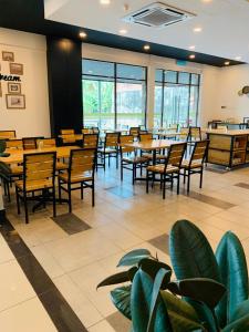 a restaurant with wooden tables and chairs and windows at Hotel Seri Malaysia Seremban in Seremban