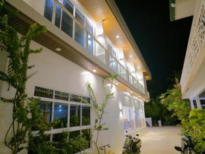 Biały budynek z roślinami na boku w obiekcie Arora View w mieście Maafushi
