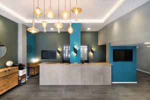 a lobby with a reception counter and blue walls at Liber Tel Aviv Sea Shore Suites BY RAPHAEL HOTELS in Tel Aviv