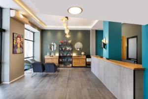 a lobby with a counter and blue walls at Liber Tel Aviv Sea Shore Suites BY RAPHAEL HOTELS in Tel Aviv