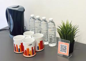 a group of water bottles and cups on a table at mySTAY Hotel BGC South in Manila