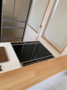 um balcão de cozinha com uma janela e um lavatório em 木漏れ日ハウス em Karuizawa