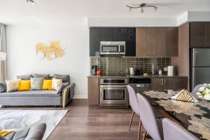 a kitchen and living room with a couch and a table at Modern Lillian St Apartments by GLOBALSTAY in Toronto