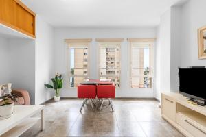 a living room with a table and two red chairs at WintoWinRentals La Malagueta Buena ubicación, Wifi in Málaga