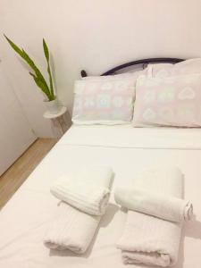 a white bed with two white towels on it at Cabuhat Duco Lodge 2 in Naic