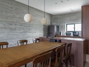 a kitchen with a large wooden table and chairs at Bosco Yomitan Resort Condminium in Yomitan