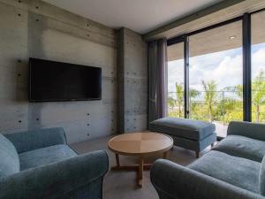 讀谷的住宿－Bosco Yomitan Resort Condminium，客厅配有2张沙发和1台平面电视