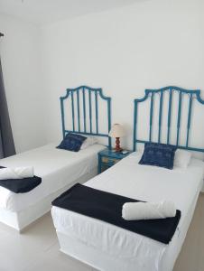 twee bedden naast elkaar in een kamer bij Magnifico Departamento, cocina equipada, 2 Recamaras 2 Baños , hasta 6 Personas, 3 albercas, playa a 50 mts wifi, aire acondicionado in Manzanillo