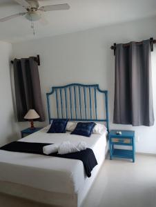 Schlafzimmer mit einem blauen und weißen Bett und einem Fenster in der Unterkunft Magnifico Departamento, cocina equipada, 2 Recamaras 2 Baños , hasta 6 Personas, 3 albercas, playa a 50 mts wifi, aire acondicionado in Manzanillo