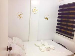 - une chambre blanche avec 2 serviettes sur un lit dans l'établissement Cabuhat Duco Lodge 2, à Naic