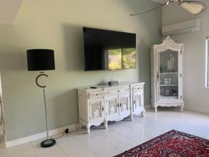 a room with a white cabinet and a television on the wall at Koombana Escape in Perth