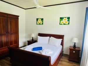 a bedroom with a bed with white sheets and a blue pillow at Happy stay villa in Grand'Anse Praslin