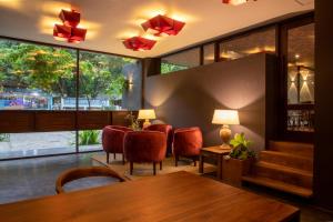 uma sala de jantar com mesa e cadeiras e janelas grandes em Lake Avenue Hotel Kandy em Kandy
