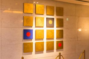 Una pared con un montón de pinturas amarillas. en Hotel il Grande Umeda, en Osaka