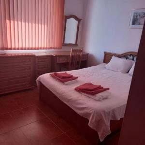 Un dormitorio con una cama con toallas rojas. en 3 Bed, 3 Bath Villa, en Kosharitsa