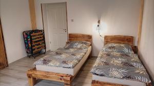 a bedroom with two beds and a chair at Zimmerferi Apartman Keszthely in Keszthely