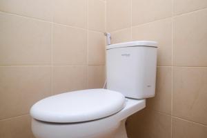 baño con aseo blanco en una habitación en RedDoorz Plus near RS JIH Solo, en Solo