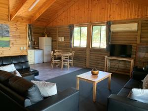 a living room with a couch and a table at Happy Wanderer Holiday Resort The Grampians in Wartook