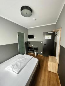 1 dormitorio con cama blanca y escritorio en Hotel Fly ´ In, en Offenbach