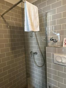 ein Bad mit einer Dusche und einem weißen Handtuch in der Unterkunft Hotel Fly ´ In in Offenbach