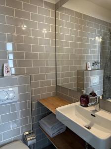 ein Badezimmer mit einem Waschbecken, einem Spiegel und einem WC in der Unterkunft Hotel Fly ´ In in Offenbach
