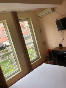 um quarto com duas janelas e uma cama num quarto em Studio Apt with Free Airport Transfer em Tŭnkovo