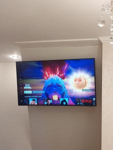 telewizor z płaskim ekranem wiszący na ścianie w obiekcie EL Mar Sole w mieście Eforie Sud