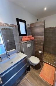 a bathroom with a tub and a toilet and a sink at Villa CAlisti in Belgodère