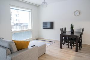 uma sala de estar com um sofá, uma mesa e uma janela em Snowflake suites VIII with private sauna em Rovaniemi