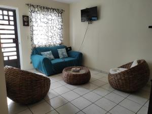 Tu casa en Mazatlan. في مازاتلان: غرفة معيشة مع أريكة زرقاء وكراسي الخوص