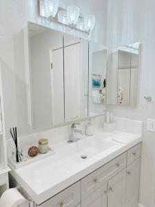 uma casa de banho branca com um lavatório e um espelho em Luxurious 2-bedrooms in Redwood + free parking em Redwood City