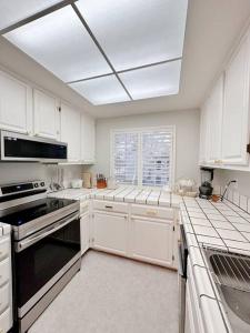 a kitchen with white cabinets and a black stove top oven at Luxurious 2-bedrooms in Redwood + free parking in Redwood City