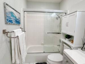 uma casa de banho branca com um chuveiro e um WC. em Luxurious 2-bedrooms in Redwood + free parking em Redwood City