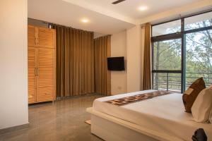 a bedroom with a large bed and a large window at Kasauli Hill Crest Luxury 2BHK Apartment in Kasauli