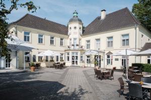 ヴェーゼルにあるHotel Haus Dudenの時計塔のある白い大きな建物