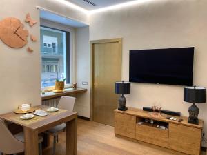 a living room with a table and a flat screen tv at Civico Cinque Home Luxury Apartment in Salerno