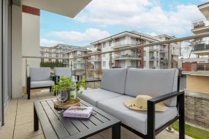 a balcony with a couch and a table at Apartament Ernesto in Rewal
