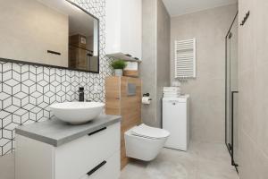 a bathroom with a white toilet and a sink at Apartament Ernesto in Rewal