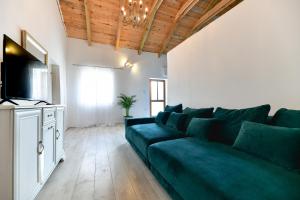un salon avec un canapé vert et une télévision dans l'établissement Villa Martin, à Zadar