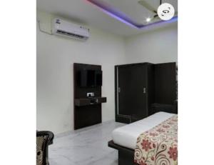 sypialnia z łóżkiem i telewizorem w obiekcie Hotel lords Highway Inn, Gagal Khas w mieście Kangra