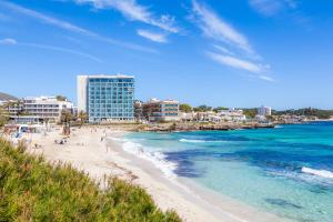 een strand met mensen op het zand en de oceaan bij Na Forana Cala Ratjada in Cala Ratjada