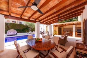 een terras met een tafel en stoelen en een zwembad bij Na Forana Cala Ratjada in Cala Ratjada