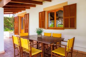 een eetkamer met een houten tafel en gele stoelen bij Na Forana Cala Ratjada in Cala Ratjada