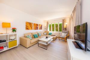 a living room with a couch and a tv at Ca Na Aina in Cala Millor