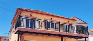 a building with a balcony on a street at Villa Roxa Montuoso in Agios Leon