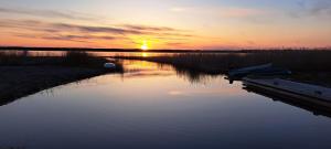 a sunset over a body of water with two boats at Suurlahe Guesthouse in Kuressaare
