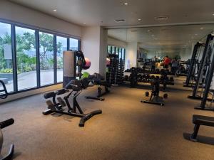 un gimnasio con cintas de correr y equipos de ejercicio en un edificio en Cozy Zen Condo 2 beds, en Cebú