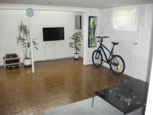 a bike parked in a living room with a television at Helle große Souterrainwohnung mit eigenem Eingang in Unterhaching